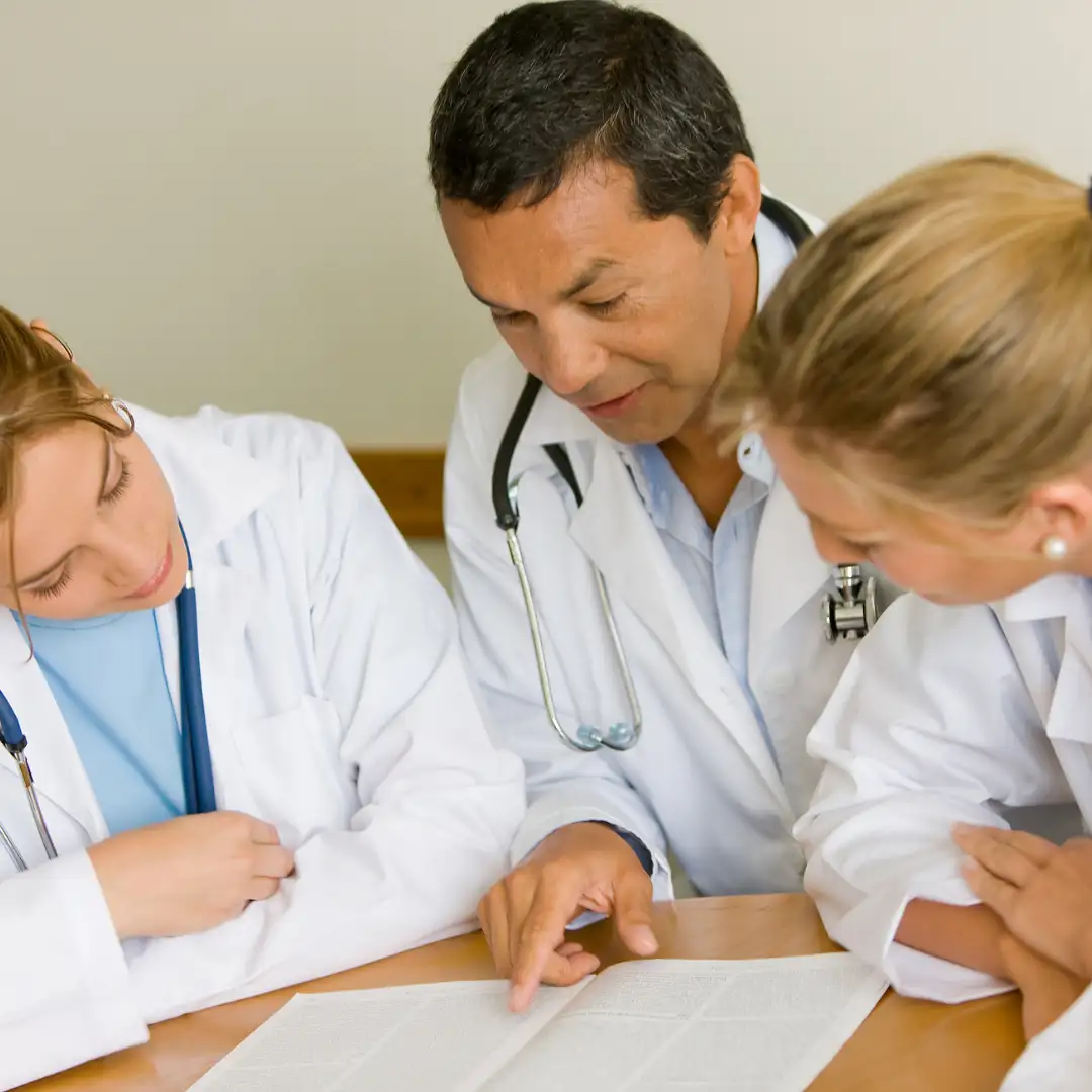 Doctor reviewing documents with two colleagues.